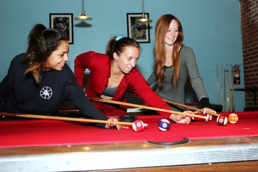 	Bela Currier, a communication senior, Camille Carlin, a communication senior and Kayla Landers, a political science senior, play pool at Sky Bar on Thursday. As the semester draws to a close, check off the final items on your UA bucket list — like wearing pajamas during a bar crawl.