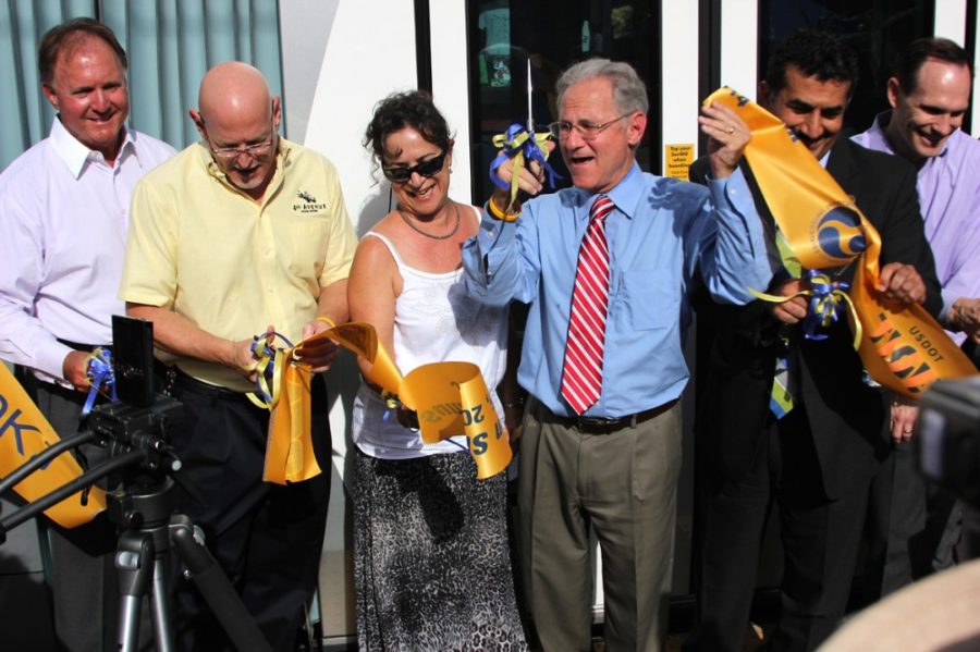 	Jonathan Rothschild (center), mayor of Tucson, along with Donna DiFiore (left of Rothschild), owner of Delecables, and Kurt Tallis (left of DiFiore), events and marketing director for 4th Avenue Merchants Association, cut the ribbon during the fourth stop, 4th Avenue and 7th st., of the Sun Link Streetcar opening ceremony Friday morning. Activities celebrating the opening of the streetcar will take place from Friday to Sunday including free rides on the streetcar. Activities celebrating the opening of the streetcar will take place from Friday to Sunday including free rides on the streetcar. 