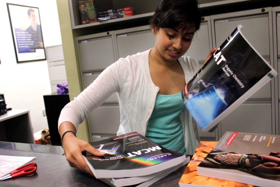 	Neuroscience junior Riyasha Daulat places testing books on shelves at the Kaplan Testing Center on Sept. 15. Students are preparing early in advance for the newer version of the Medical College Admission Test.