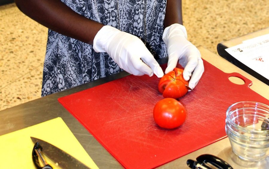 	Nutritional sciences junior major Dorine Owusu-nyarko prepares tomatoes for a mason jar salad during the Student Recreation Center’s Cooking on Campus class. The next class is scheduled for Sept. 9.
