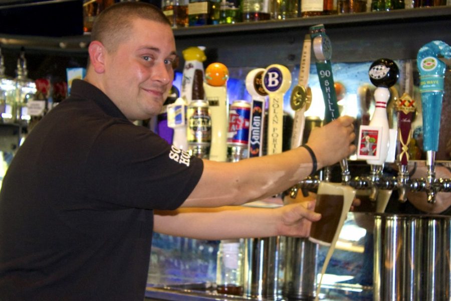 	Greg Turkington, a bartender at Social House, pours a beer from the tap.