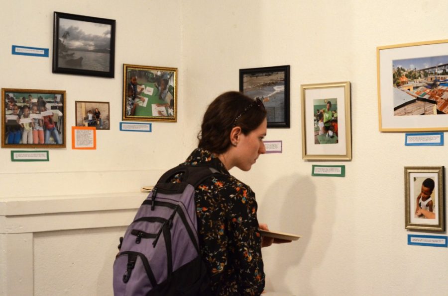Brenna Wagner, a junior in chemical engineering, peruses the array of  photos captured by graduate students within the School of Geography and  Development on their studies abroad at Cafe Passé on Thursday. Wagner  said she came to the exhibit to support and view her friends work.