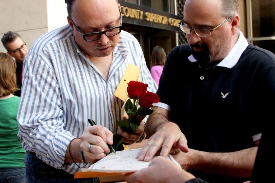 Lawrence Loussaert and Joseph Spoors sign their marriage certificate in front of the Arizona Superior Court in Pima County courthouse on Friday. Loussaert and Spoors have been together for 23 years.
