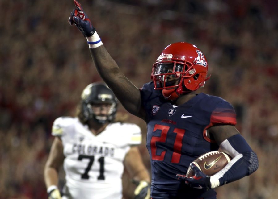 <p>Arizona safety Tra'Mayne Bondurant (21) scoops and scores a touchdown after Colorado quarterback Sefo Liufau fumbled during the first half of Arizona's 38-20 win against Colorado at Arizona Stadium on Saturday. The Wildcats scored 28 points off of turnovers against the Buffaloes.</p>