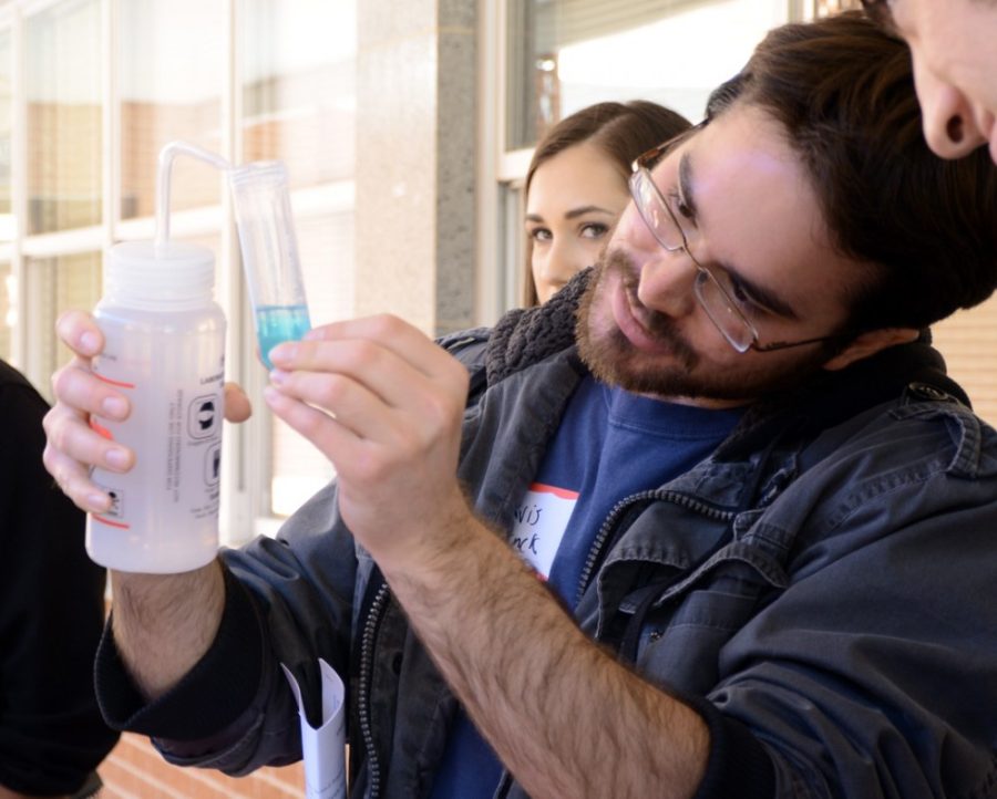 Molecular and cellular biology student Travis Struck demonstrates how to  extract DNA from cheek cells at the Stevie Eller Dance Theatre on  Saturday. The Undergraduate Biology Research Program holds a yearly  conference to showcase student research.