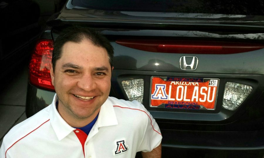Courtesy of Josh MillerUA alumnus Josh Miller stands next to his license plate stating LOLASU. The Arizona Department of Transportation informed Miller that he would have to return his license plate following an anonymous complaint.