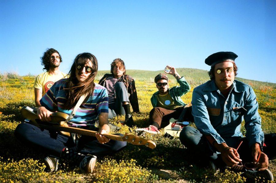 Courtesy of Taylor Bonin Members of The Growlers pose with their instruments in a field of flowers. The band will be performing at Hotel Congress at 7 p.m.