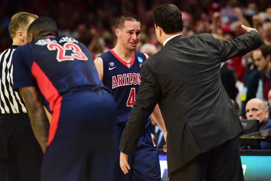 Arizona guard TJ McConnell (4) walks off the court for the last time in his Arizona basketball career to hug coach Sean Miller after Arizonas heartbreaking 85-78 loss to Wisconsin in the Elite Eight of the NCAA Tournament in the Staples Center in Los Angeles, Calif. on Saturday evening.