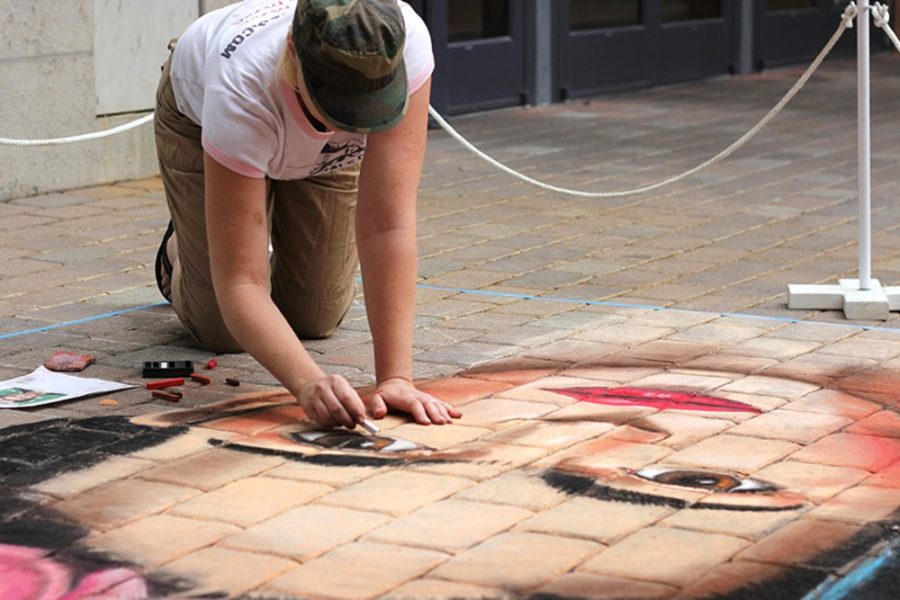 Rebecca Marie Sasnett/The Daily Wildcat

Muralist Gina Ribaudo blends brown and tan color chalk as she finishes her Frida Khalo chalk drawing in front of Park Place Mall on Sunday. Ribaudo has been creating murals for 20 years.  