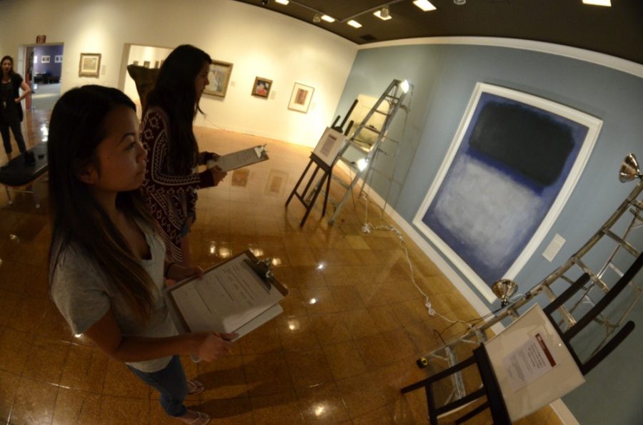 Tiffany Luu, a public management & policy senior, left, and Mikayla Mace, a neuroscience & cognitive science senior, right, view a Rothko painting under changing light in the University of Arizona Museum of Art on Wednesday, March 25, 2015.