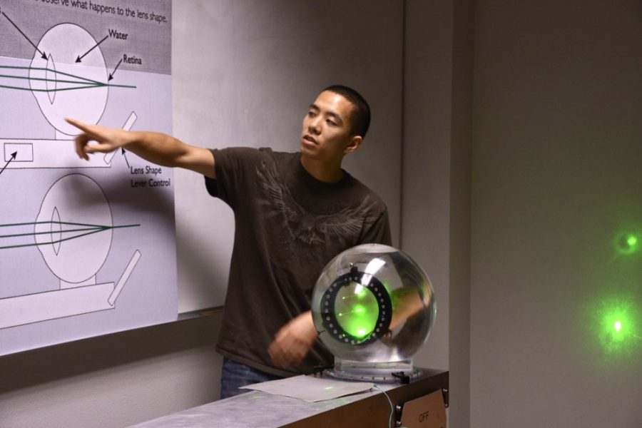Elliott Kwan, an optical sciences graduate student, demonstrates how the human eye works and the effects as humans age during the College of Optical Sciences Laser Fun Day in the Meinel Optical Sciences building on Saturday. The event brought attention to the different applications of optics.