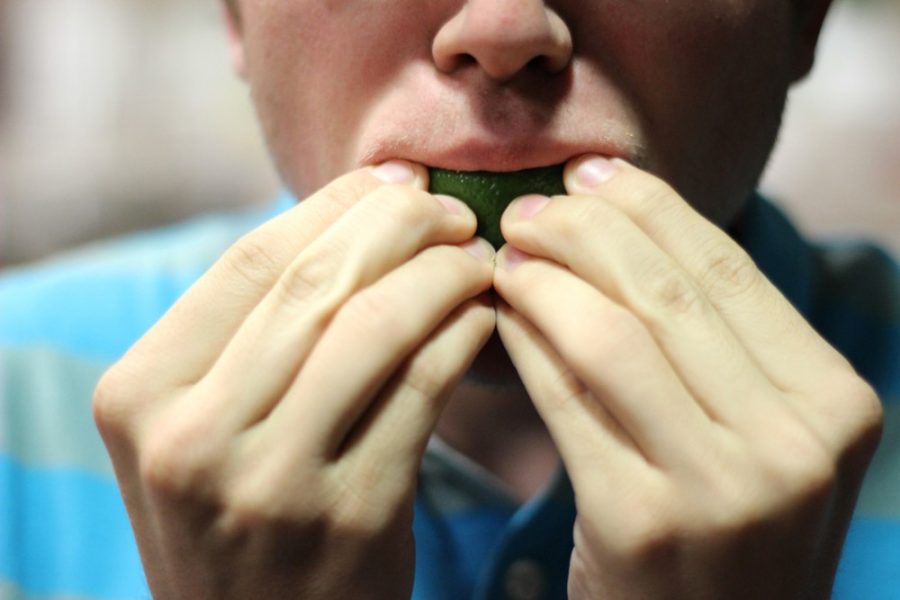 A young man bites into a tangy lime. Like the popular Ice Bucket Challenge, The Take a Bite Out of Lyme Disease challenge encourages participants to raise money and awareness for Lyme disease.
