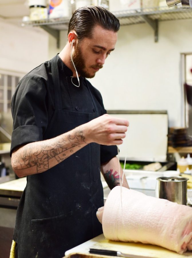 Head chef Drew Buono ties a pork body for the brind and smoke pork belly special at Pasco Kitchen & Lounge on Thursday night to be served at Viva La Local Food Festival.