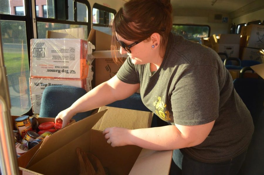 Sophomore Kelsie Rogers puts donated food in boxes on the CatTran on Wednesday afternoon. This marked the seventh year the UA and Community Food Bank have coordinated the Stuff the CatTran event.