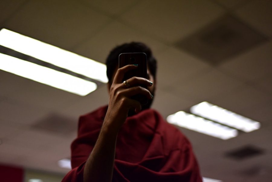 An undergraduate student takes a selfie. Unlike the use of personal pronouns like “I,” research has shown a connection between men who frequently take selfies and narcissistic traits.