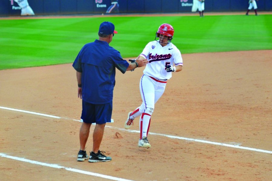 Arizona softball utility Hallie Wilson (5) high-fives coach Mike Candrea on her way home during Arizonas 22-5 win against Stanford at Hillenbrand Stadium on Sunday. Wilson collected eight RBIs on Sunday to complete the sweep over Stanford.