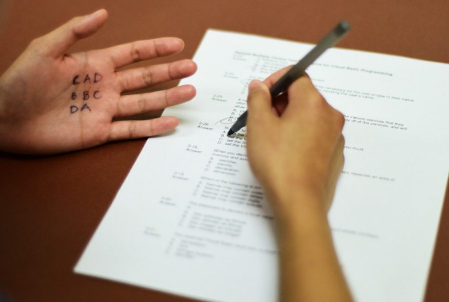 A student uses the answers written on her palm to cheat on a test. Reports show that over 800 students violated the Code of Academic Integrity just last year.