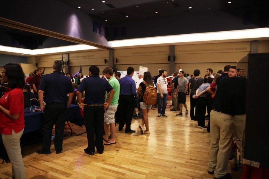 Students browse booths at Engineering Design Day in the Student Union Memorial Center on Tuesday. The Interdisciplinary Engineering Design Program divides seniors from the College of Engineering into teams, working with sponsors such as Raytheon, Tucson Electric Power and Honeywell.