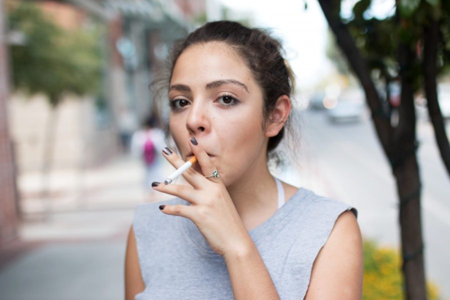 Ana Lucia Quinones, a junior studying film and television, smokes a cigarette on Park Avenue on the UA campus Tuesday, Aug. 25.