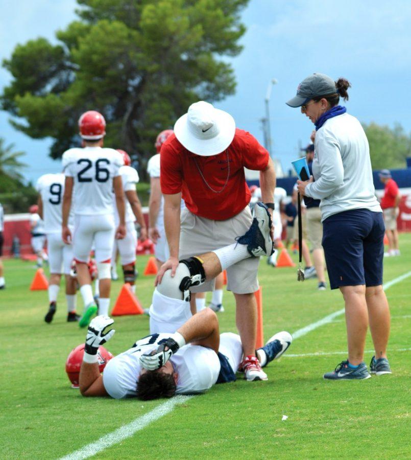 An+Arizona+Athletics+trainer+stretches+offensive+lineman+T.D.+Grosss+leg+at+practice+on+Sunday.+Trainers+work+with+athletes+to+treat+and+prevent+injuries.