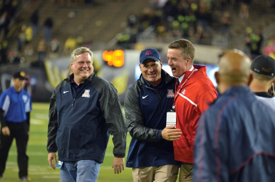 Arizona athletic director Greg Byrne, in red, celebrates with head coach Rich Rodriguez, center, after Arizonas win versus Oregon on Thursday, Oct. 2, 2014.