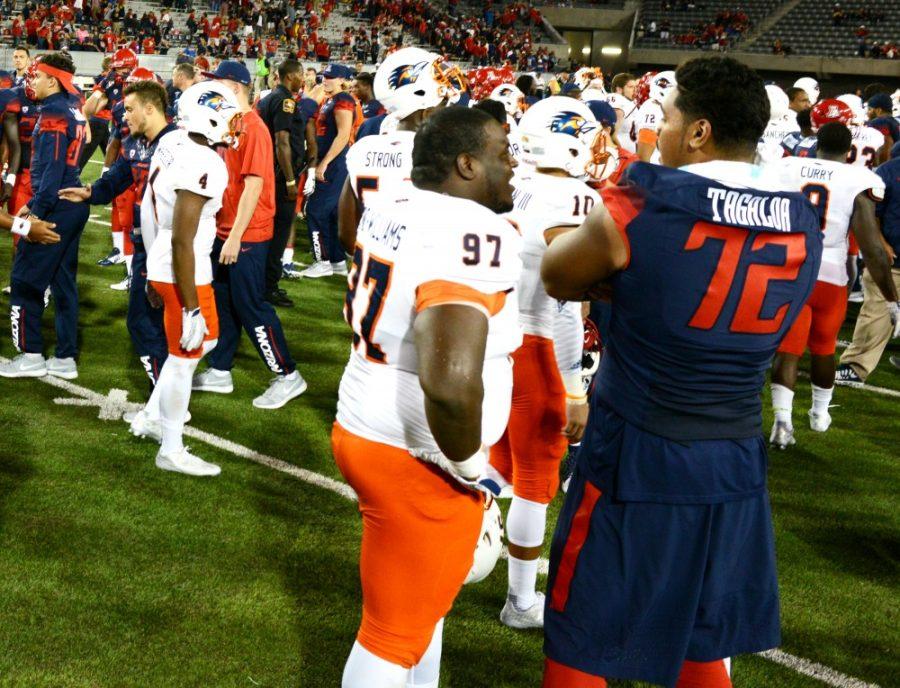 Arizona offensive lineman Freddie Tagaloa (72) chats with UTSA defensive tackle Vontrell King-Williams (97) in Arizona Stadium following the Wildcats win on Thursday, Sept. 3.