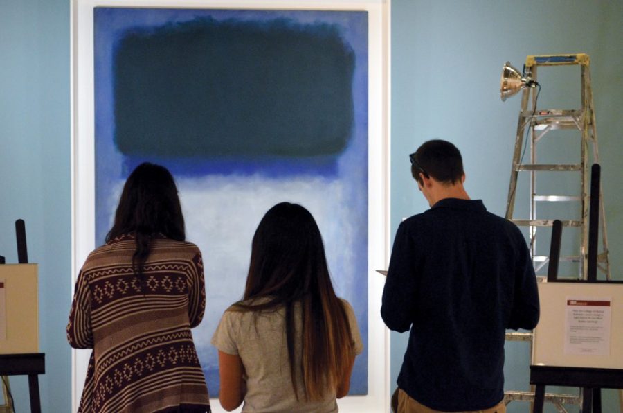 Mikayla Mace, a senior studying neuroscience & cognitive science, left, Tiffany Luu, a public management & policy senior, center, and Jay Stephens, an archaeology grad student, right, behold a Rothko painting under different colors of light at the University of Arizona Museum of Art on Wednesday, March 25, 2015. The exhibit, a collaboration between the museum and the College of Optical Sciences, is part of the Month of Light.