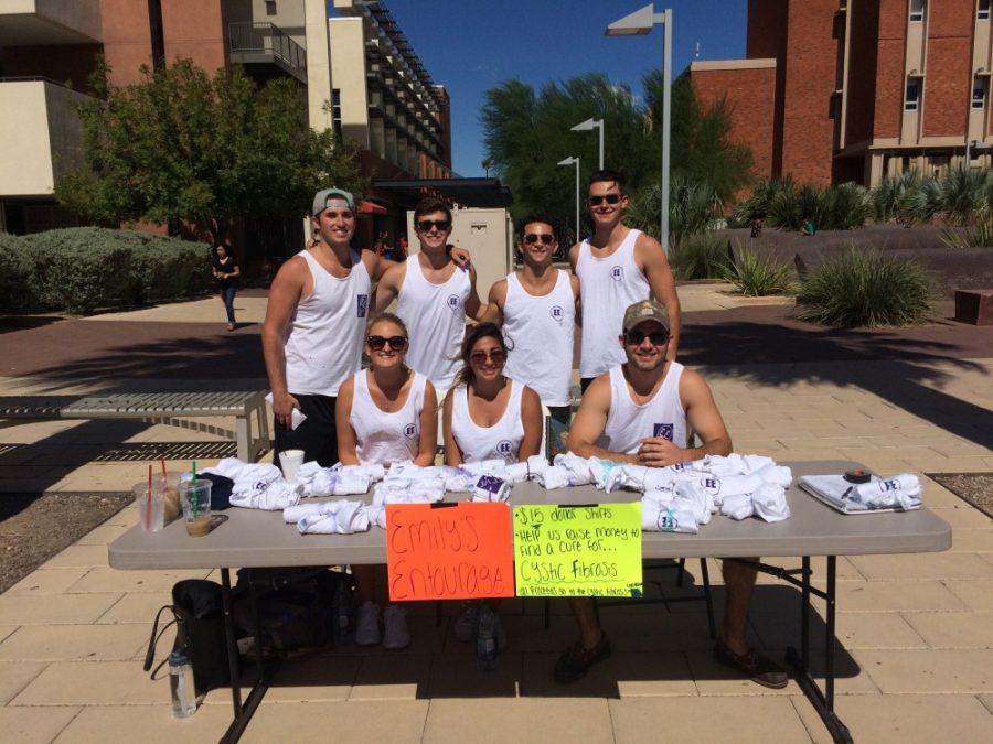 U of A students gather around their table on the mall to sell tanks to support cystic fibrosis research efforts. Courtesy of Camden Weisz.