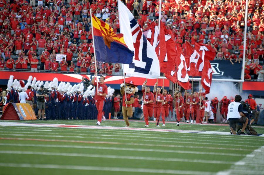 Arizona cheerleaders run onto the field with flags held high at Arizona Stadium before the Wildcats game against UCLA on Saturday, Sept. 26. Week five of the college football season brought injuries, miscues and top upsets. 