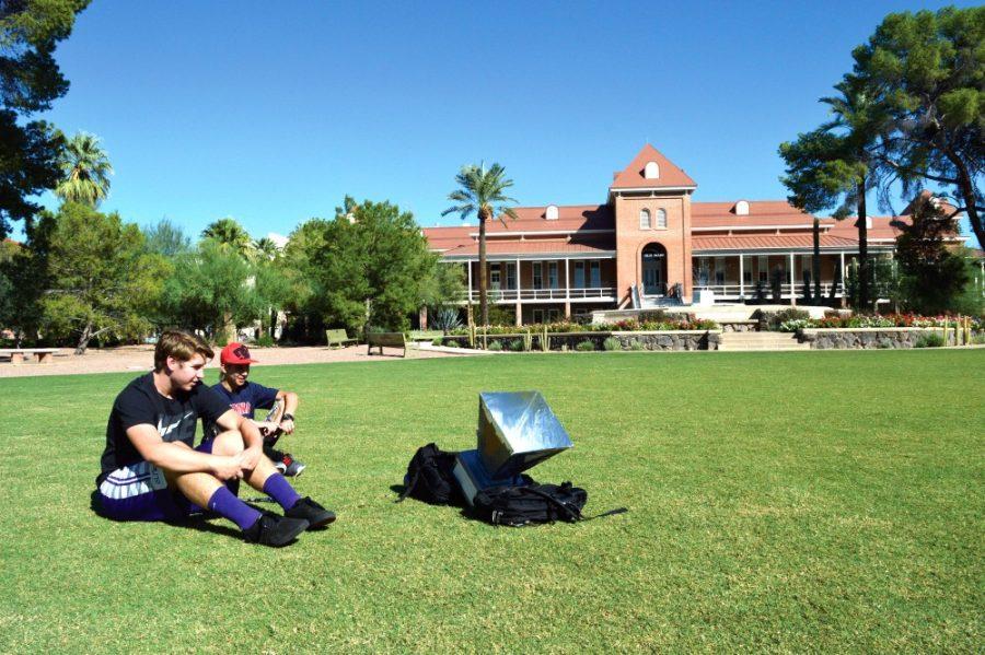 Adam Grey, Engineering Freshmen, and Caelan Caudell, Engineering Freshman, sit in the grass area in front of Old Main on tuesday afternnon as they charge their Solar powered oven. Their attempts are to cook a biscuit by generating enough heat through solar charge. 

Photographed by Jesus Barrera