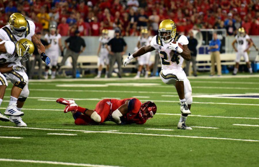 <p>UCLA running back Paul Perkins (24) evades a tackle by Arizona during the Wildcat's loss on Saturday, Sept. 26. at Arizona Stadium.</p>