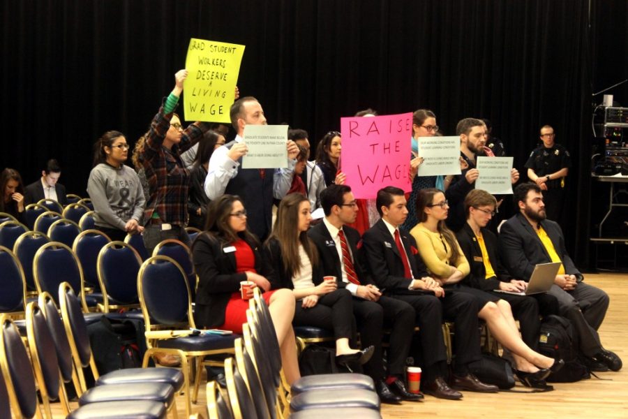 Protestors stand and hold signs during the  Arizona Board of Regents meeting Friday, Nov. 20. The protestors were there to show their support for the GSOC and others who were voicing their opinions on the mistreatment of graduate teaching assistants, non tenure-track faculty and adjunct professors by the universities.