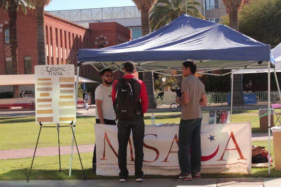 Omar Phanivong and Mohammad Adlan Fauzi of the UAs Muslim Student Association educate students about Islam on Thursday, Nov. 19 on the UA mall. The club set up a booth on the Mall to answer questions about the Islamic faith, which they will continue to do every Thursday.