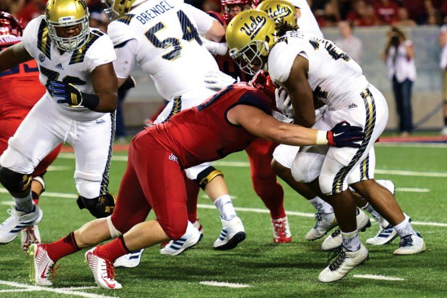 Arizona defensive linebacker Scooby Wright III (33) latches onto UCLA running back Paul Perkins (24) at Arizona Stadium on Saturday, Sept. 26. Wright returned to practice this week and is expected to play in the Wildcats bowl game.