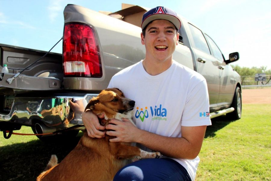 A member of the VIDA club plays with a dog at the Dogtoberfest fundraiser. The VIDA club puts on fundraisers to make money for upcoming trips. 