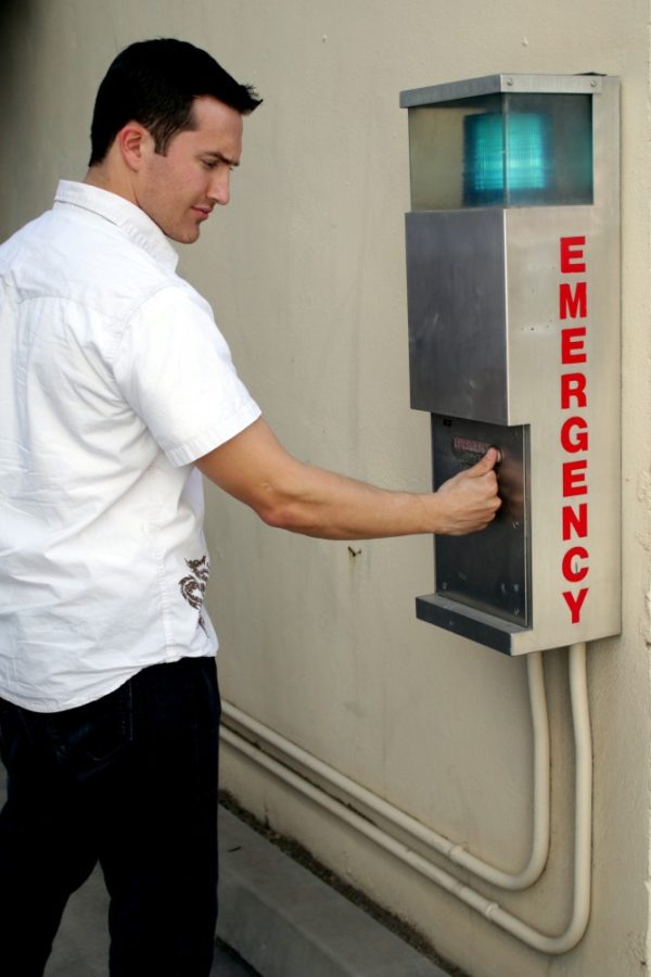 Colin Lynch, a neuroscience senior, poses with the emergency response button near the Music building on UA campus on Sunday, Feb. 14. The UA created a bystander intervention program in 2008, which is currently being used across the country.