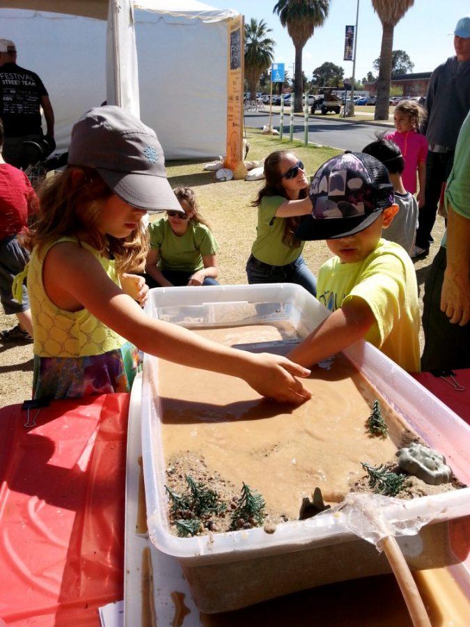 Children play at a stream table at the UA Department of Geosciences booth in Science City at last years Tucson Festival of Books. The stream table, along with many other hands-on activities, will be available during the festival in the six Science City neighborhoods.