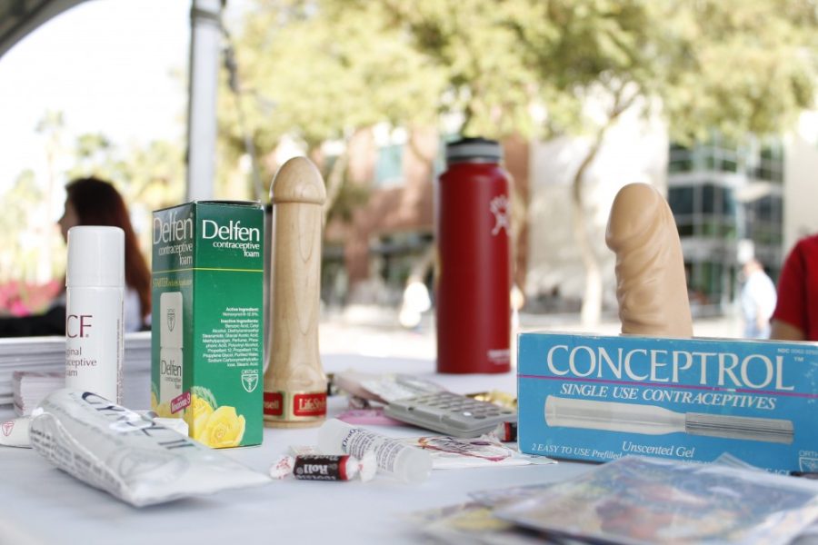 Dildos and contraceptives lie on a table on the UA Mall for the Spring Break Safety Fair on Wednesday, March 2. Libby Valdez, a public health graduate student, was in charge of the table advocating for sexual health and safety over spring break.
