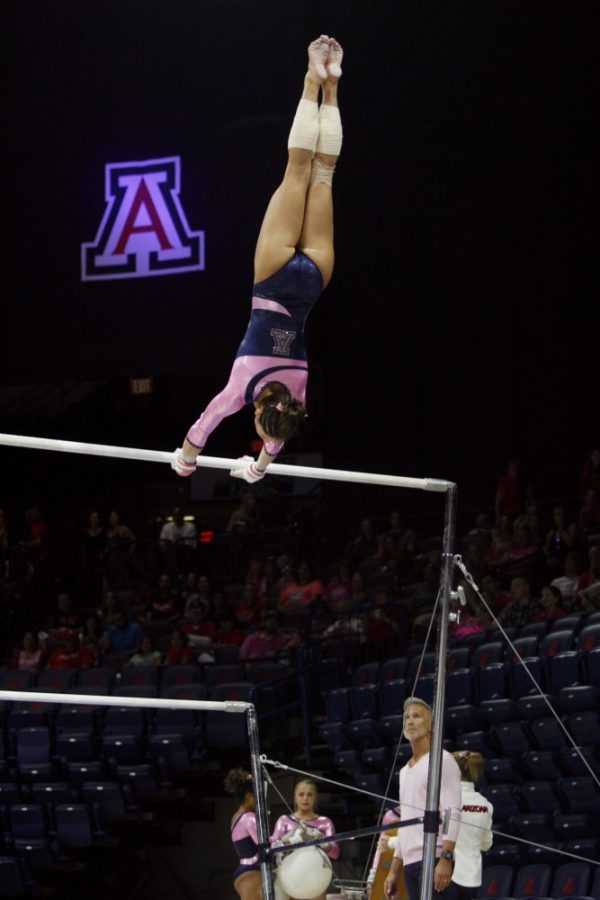 Arizona gymnastics senior Lexi Mills performs on the uneven bars during a meet against Washington on Feb 27 at McKale Center.