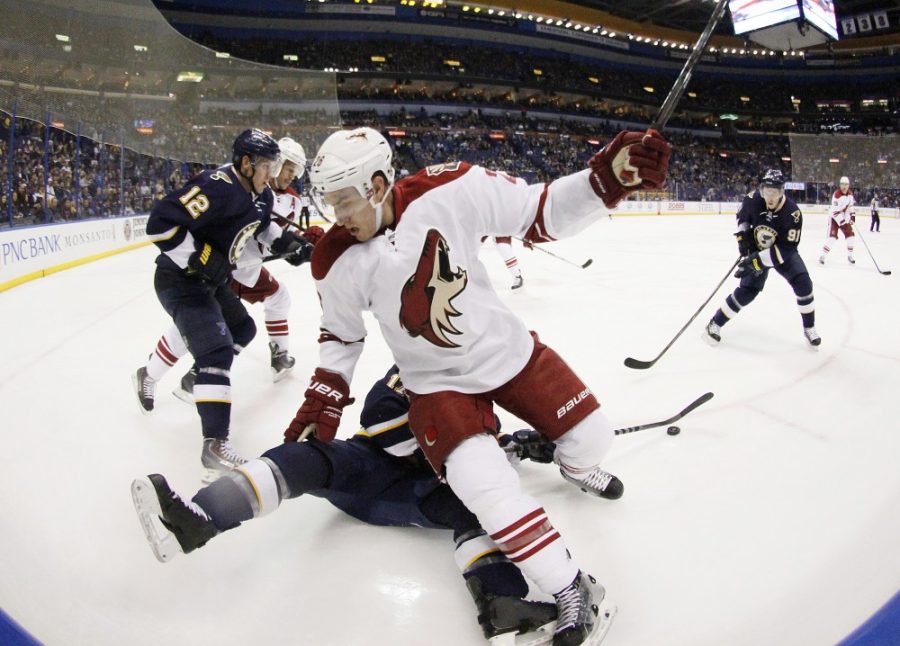 Arizona Coyotes defenseman Michael Stone falls over St. Louis Blues left wing Jaden Schwartz during first period action on Tuesday, Feb. 10, 2015, at the Scottrade Center in St. Louis.