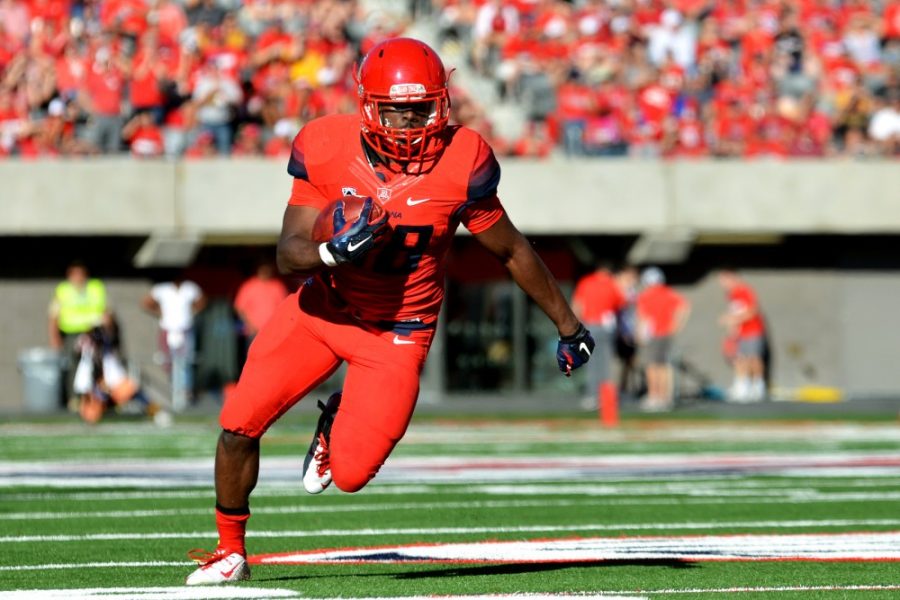 Arizona running back Nick Wilson (28) runs on his way to a touchdown against Arizona State during the 2014 Territorial Cup at Arizona Stadium Nov. 28, 2014.

