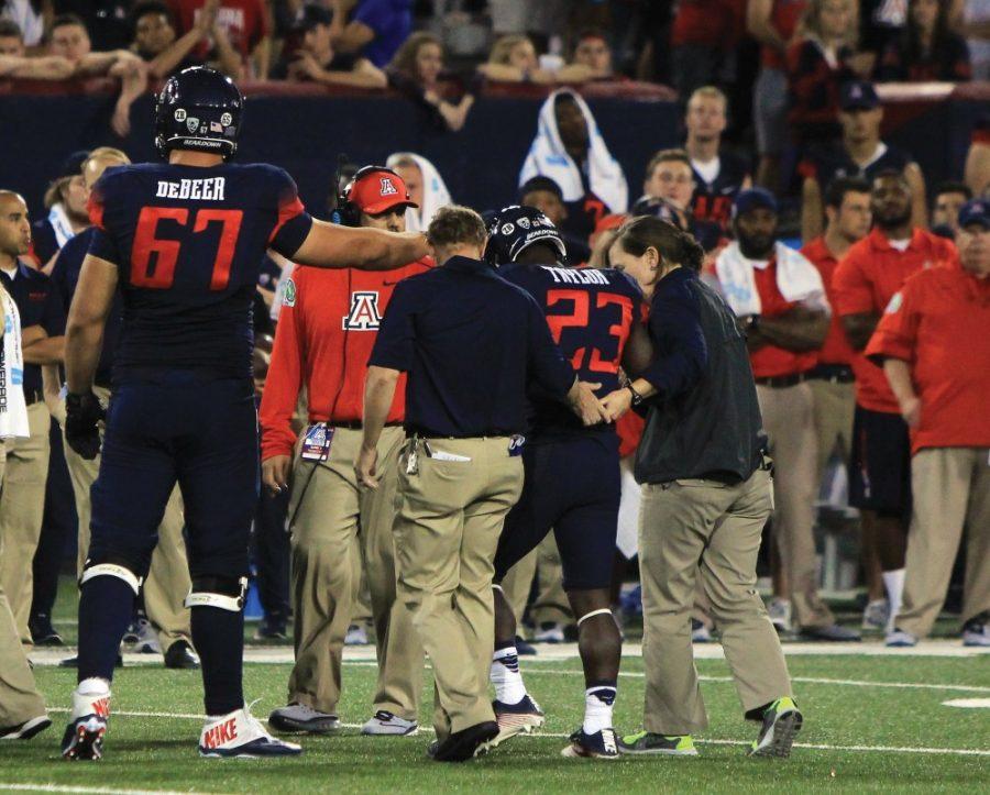 Arizona running back J.J. Taylor (23) is escorted off the field after injuring his ankle in Saturdays game against No. 9 Washington at Arizona Stadium. Taylor had rushed for 97 yards and a touchdown before the injury.