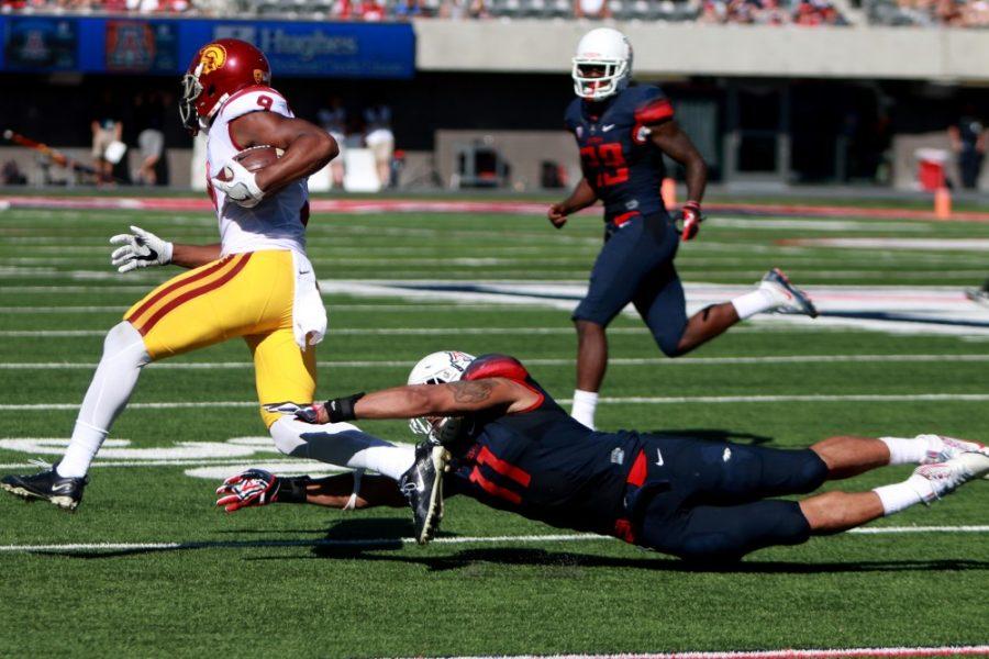 Arizona linebacker Michael Barton (11) lunges in an attempt to wrap-up USC wide receiver JuJu Smith-Schuster (9) during Arizonas 48-14 loss to the Trojans at Arizona Stadium on Saturday, Oct. 15. Smith-Schuster finished with nine catches for 132 yards and three touchdowns.