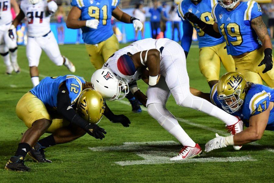 Arizona quarterback Khalil Tate (middle) goes head-to-head with UCLA linebacker Jayon Brown (12) during Arizonas 45-24 loss to UCLA at the Rose Bowl Stadium in Pasadena, Calif., on Saturday, Oct. 1, 2016.