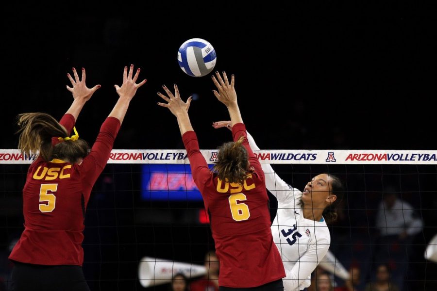Arizona outside hitter Tyler Spriggs (35) spikes the ball over USC Trojans Jordan Dunn (5) and Brittany Abercrombie (6) in Wednesdays game in Tucson, Arizona. Wildcats won #25 ranked USC Trojans 3-2.