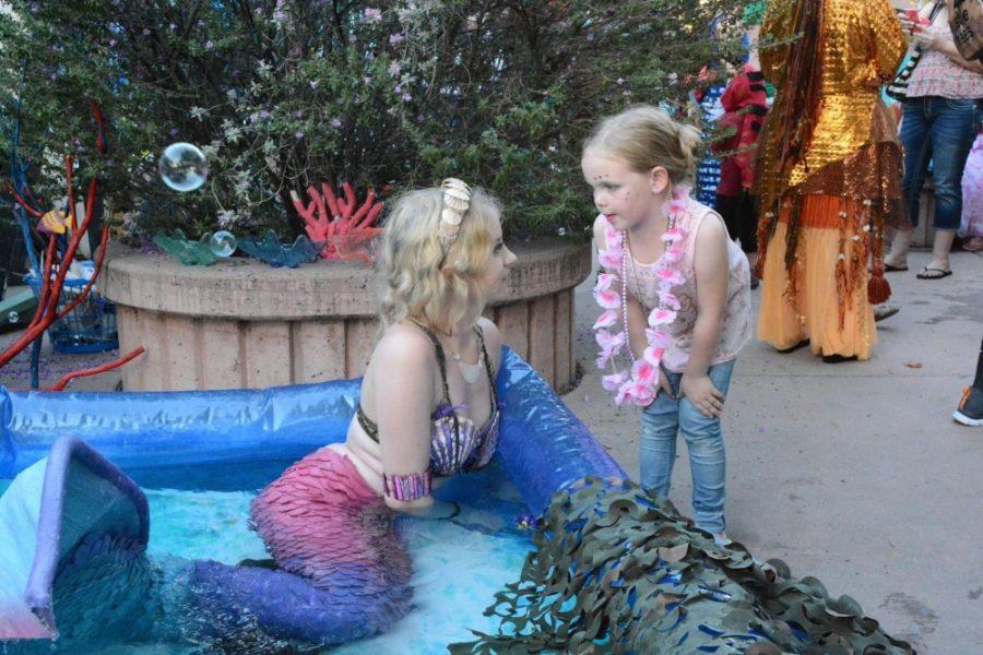 Mermaid Odette makes a new human friend at Return of the Mermaids in August 2016. The mermaid-themed event on Fourth Avenue and Downtown is one of the aquatic performers most popular gigs.