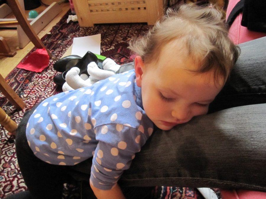 Mathilde, fighting sleep, falls fast asleep on her mothers legs. New UA research aims to investigate the connection between the amount a toddler sleeps and new information retainment.