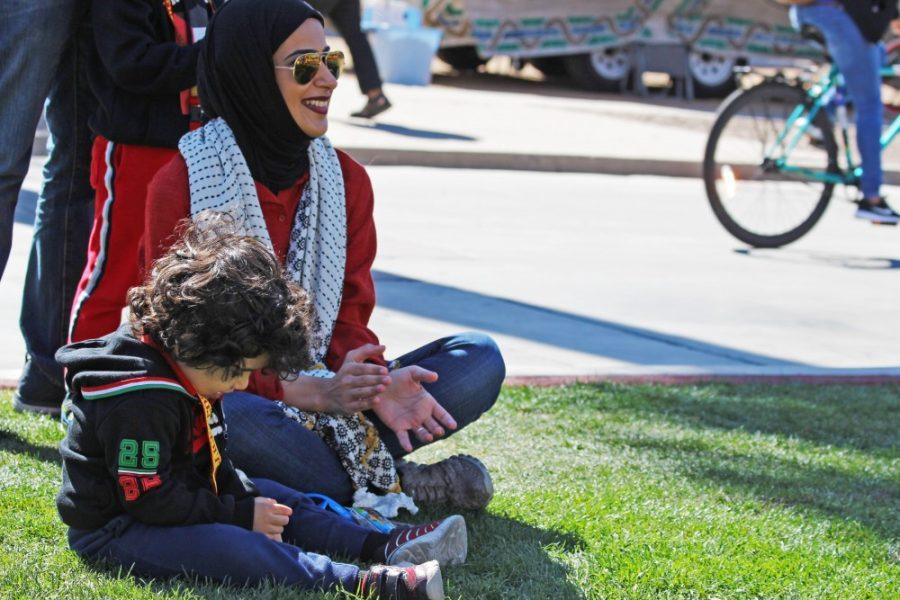 A mother and son happily watch Kuwait students sing at the CESL festival on the UA Mall on Feb. 15. The Kuwait students sang and danced to songs that they chose.