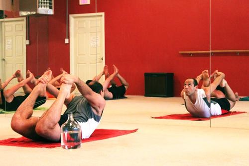 Aric Mokhtarian (white shirt) practices Bikram yoga. UA’s award winning services include: a sick child and emergency care program, employee wellness and health promotion, stress management, mindfulness and relationship-building resources and walks with campus leaders.