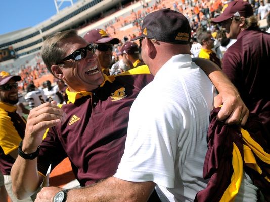 Central Michigans athletic director Dave Heeke, left, celebrates with CMU head coach John Bonamego after the teams 30-27 win over Oklahoma State in Stillwater, Okla., Saturday, Sept. 10, 2016.
